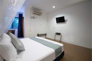 hotel bedroom with a deluxe king mattress and a small tv on the wall